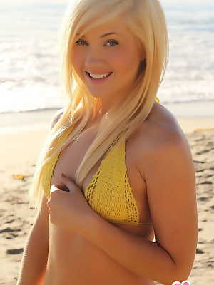 Blonde glamour model Ashlie Madison poses alone on a beach in a yellow bikini