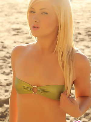 Young looking blonde girl Ashlie Madison cups her flat chest via bikini top