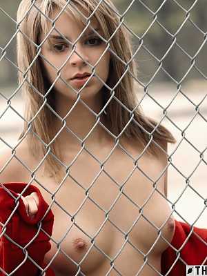 Pretty blonde Aspen Martin gets naked against a chain-link fence