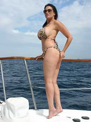 Curvy brunette MILF Ava Lauren poses in a leopard bikini on a yacht