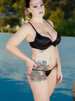 Tattooed model Axis Evol showing her thick body and big ass by the water