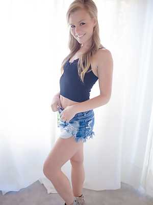 Blonde American girl Nicole Clitman slips jean shorts over her ass and twat