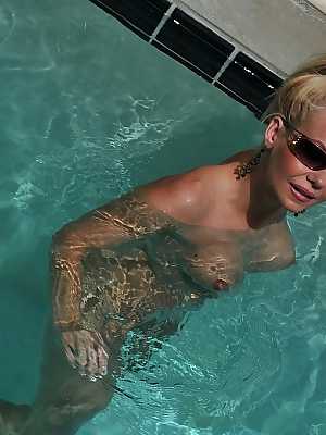 Cute blonde MILF Barbi Sinclair shows her fantastic body wearing sexy bikini in the pool.