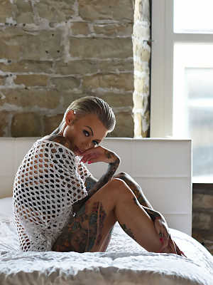 Gorgeous inked babe Becky Holt shows her tattoos and strips in a solo