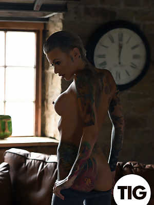 Glamorous tattooed babe Becky Holt stripping on the leather sofa