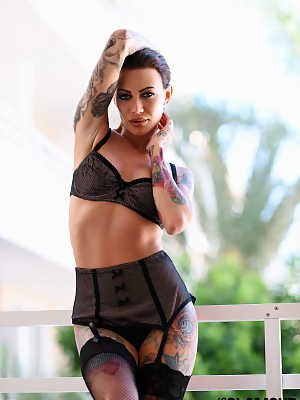 Sexy tattooed model Becky Holt posing in exotic lingerie on the balcony