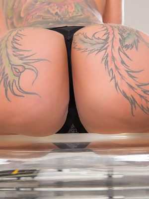 Heavily tattooed female Bella Bellz rocks her juicy ass as she gets naked