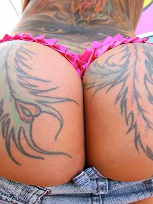 Tattooed Bella Bellz drops her shorts uncovering her very round bubble butt