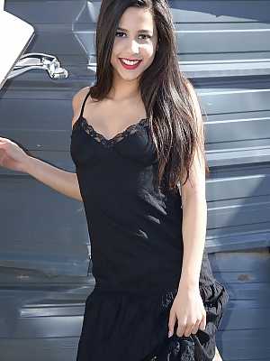 Dark haired amateur Bella Quinn models a black dress outdoors in junkyard