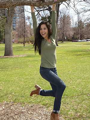 Latina chick Bella Quinn climbs a tree in the park wearing a sweater and jeans