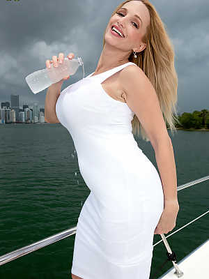 Middle-age woman Billi Bardot puts her fake tits on display upon a boat
