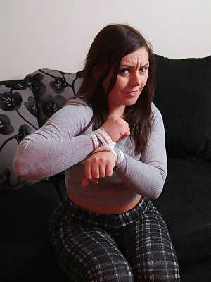 British chick Kacie James is bound with rope on a loveseat while fully clothed