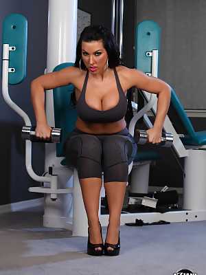 Dark haired female Brianna Jordan whips out her nice melons while working out