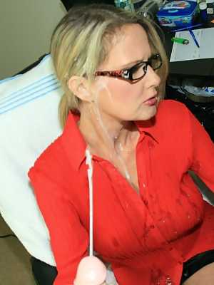 Fully clothed mature blonde in glasses gives a handjob and gets bukkaked