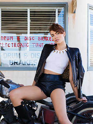 Short haired babe Britt Linn showing her tiny tits near her motorbike