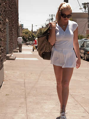 Brooke Belle walks in the street in super-sexy short white dress and heels