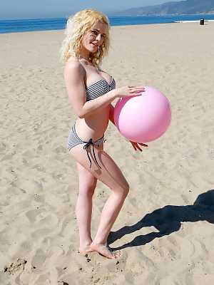 Adorable blonde beach bunny drops her bikini top to sun her sexy natural tits