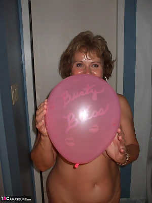 Mature lady models totally naked while playing with balloons