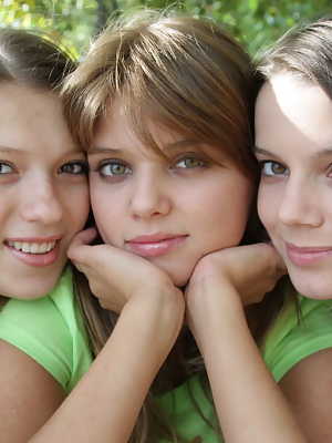 Three young looking girls gets naked on a wooden bench in the countryside