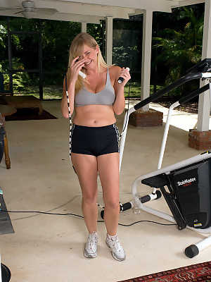 Busty blonde MILF exposes her big natural tits while working out at the gym