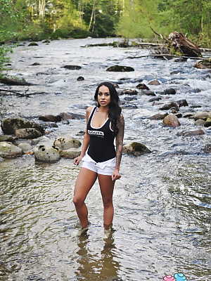 Latina teen Cindy Cupcakes pulls down her shorts while standing in a river