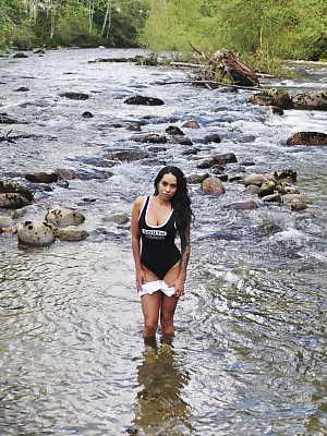 Latina teen Cindy Cupcakes pulls down her shorts while standing in a river