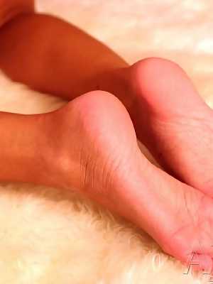 Brunette pornstar Crissy Moran licks her toes after revealing her fake titties