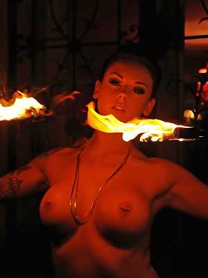 Femdom Daniela gives an outdoor fire-play performance with her big boobs bared