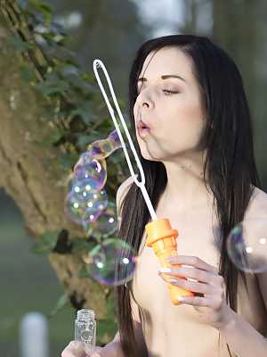 Pale-skinned brunette Daniella Rose nudes tits and blows bubbles by the lake