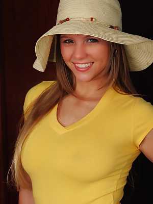 Curvy chick Dawson Miller purses her lips before getting naked in a sun hat