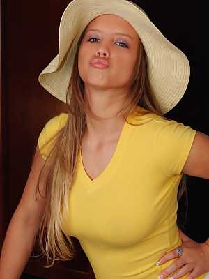 Curvy chick Dawson Miller purses her lips before getting naked in a sun hat