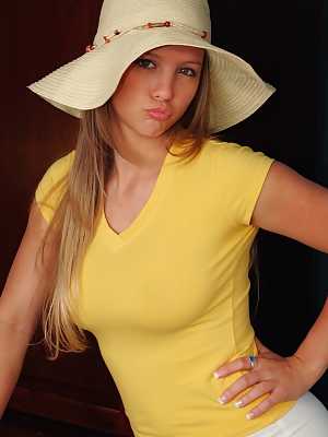 Curvy chick Dawson Miller purses her lips before getting naked in a sun hat