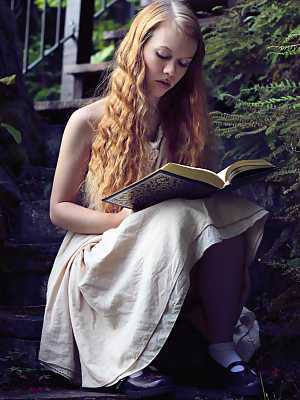 Young redhead Dolly Little exposes herself on garden steps while reading