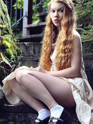 Young redhead Dolly Little exposes herself on garden steps while reading