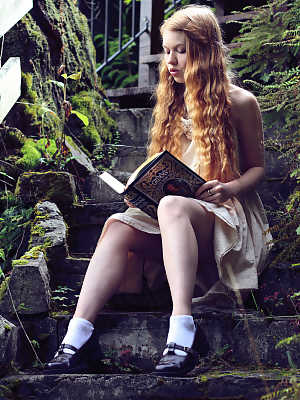 Young redhead Dolly Little exposes herself on garden steps while reading