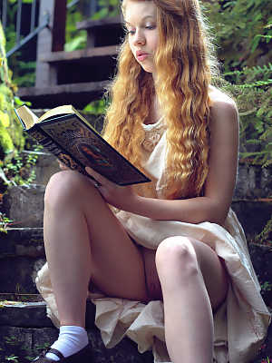 Young redhead Dolly Little exposes herself on garden steps while reading