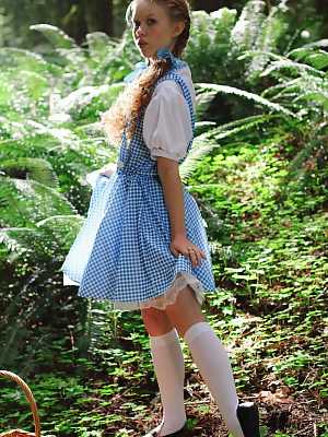 Charming redhead teen Dolly Little gets naked in white socks while in a forest