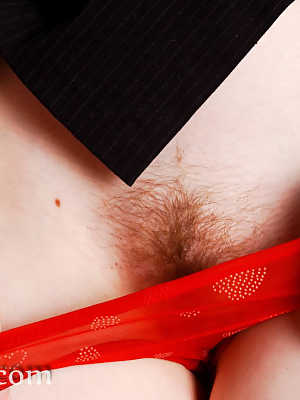 Pale redhead Elli Nude shows her bare legs before masturbating