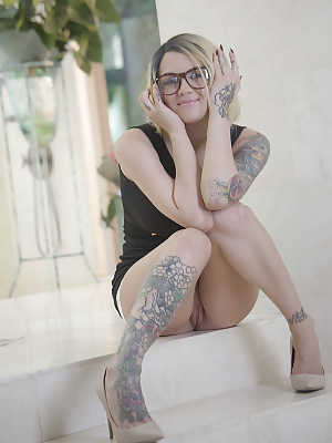 Inked babe in glasses revealing shaved pussy after shedding dress