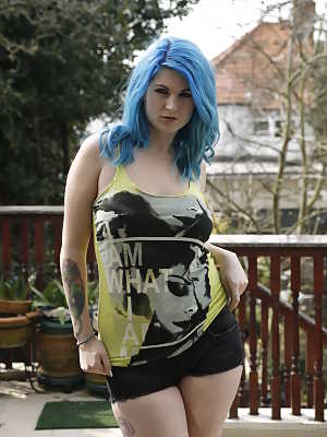 Thick amateur Emma J Black sports blue hair while stripping on a deck