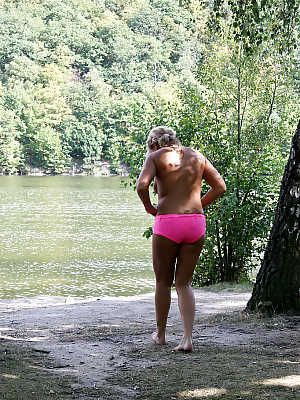 Naughty MILF taking off her swimsuit and exposing her goods outdoor