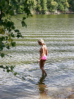 Naughty MILF taking off her swimsuit and exposing her goods outdoor