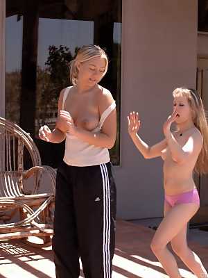 Tiny blonde is picked up off the ground by a blonde girl after a karate fight