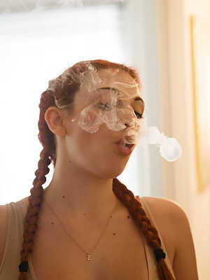 Redhead teen Gina Rosini smokes and shows her big breasts indoors