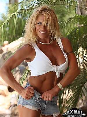 Blonde bodybuilder Gina doffs halter top and jean shorts to pose nude