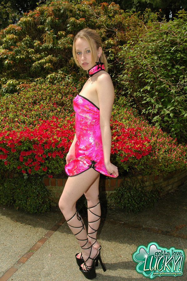 Young amateur Lucky partially removes a pretty dress near blooming bushes