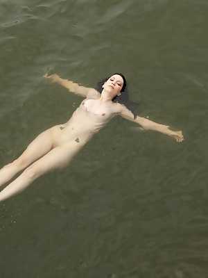 Inked model Marlo Marquise takes off her bikini and poses nude at the river