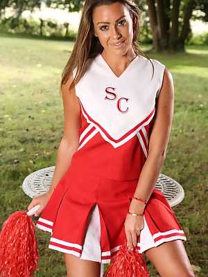 Beautiful cheerleader Harriette undressing outdoors and posing in red panties