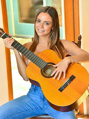 Topless girl slips faded jeans over her phat ass before strumming a guitar