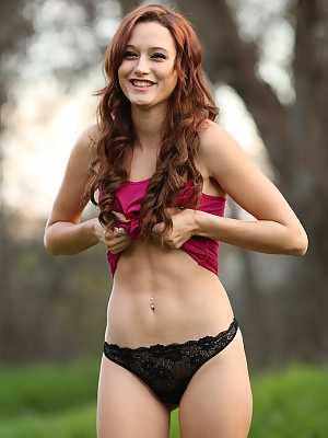 Redhead amateur Hayden Ryan slides legging over thong atop fallen tree